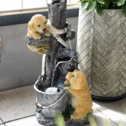 Solarbrunnen Hundewelpen Milo und Buddy an beleuchteter Wasserquelle
