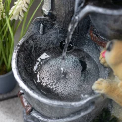 Solarbrunnen Hundewelpen Milo und Buddy an beleuchteter Wasserquelle