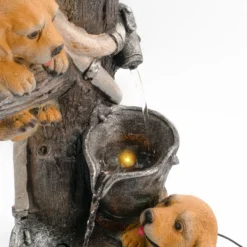Solarbrunnen Hundewelpen Milo und Buddy an beleuchteter Wasserquelle